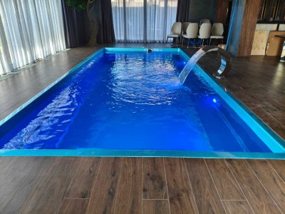 Крытый прямоугольный бассейн с подсветкой и нержавеющим водопадом в комнате